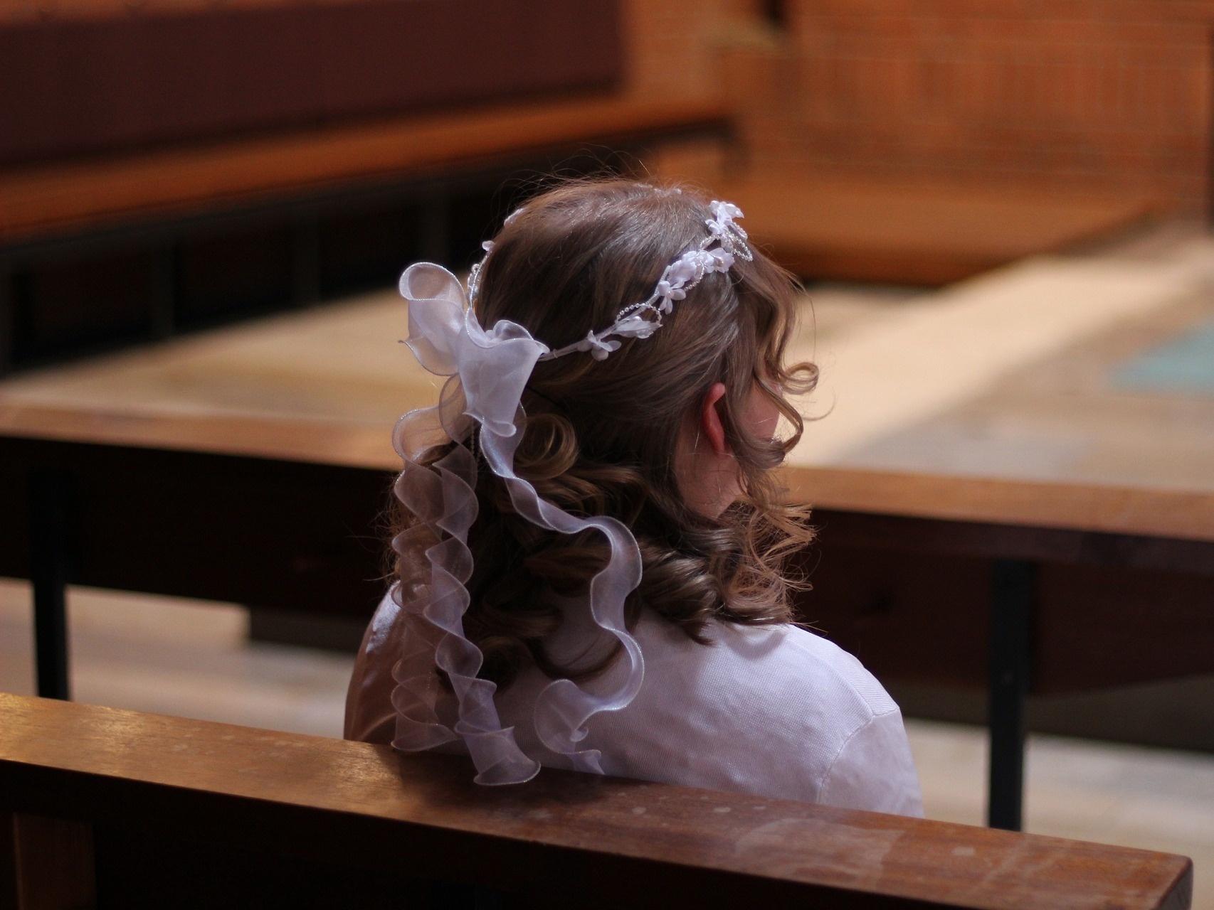 Kommunionkind in Kirchenbank Kommunionkind in Kirchenbank